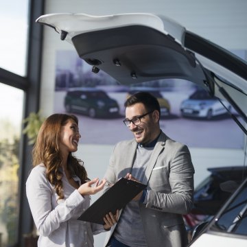 usaa extended car warranty woman signing car warranty held by happy man with glasses
